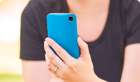 Person holding up a smartphone in a blue phone case