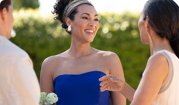 Person in a blue dress talking within a group of three