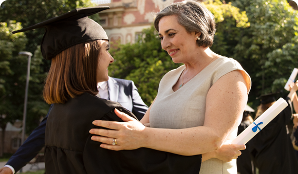 Graduate Holding Diploma and Hugging a Family Member