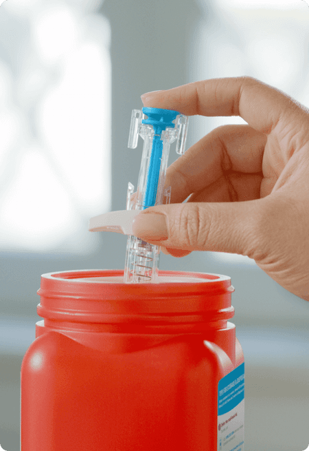 SKYRIZI syringe disposed in a sharps container